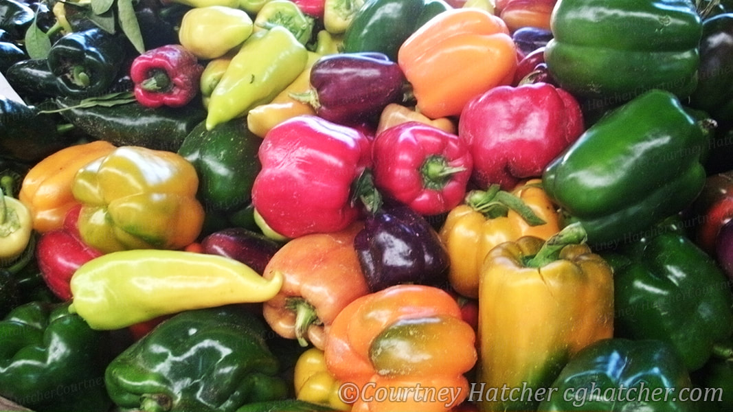 Pepper's in a pile at the farmer's market.  Photography by Courtney Hatcher.  Bright colors full of life.